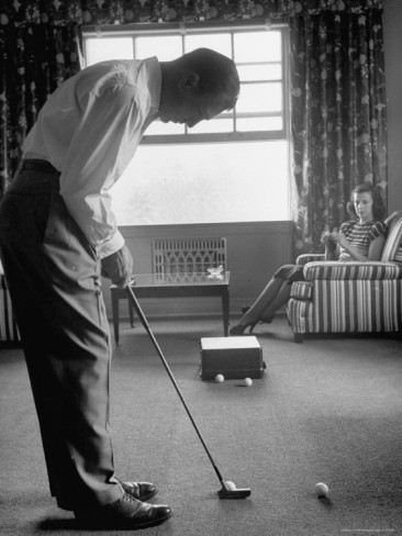 loomis-dean-golfer-ben-hogan-practicing-putting-in-his-town-house-with-wife-valerie-watching-from-armchair